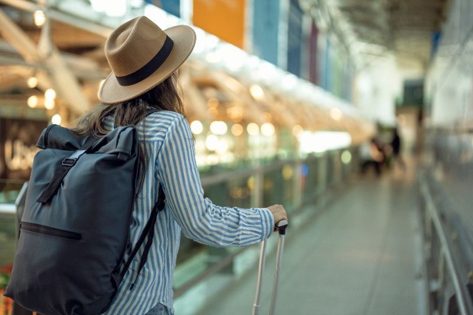 A woman walking with a backpack and suitcase by Johnston Meier Insurance Agencies Group