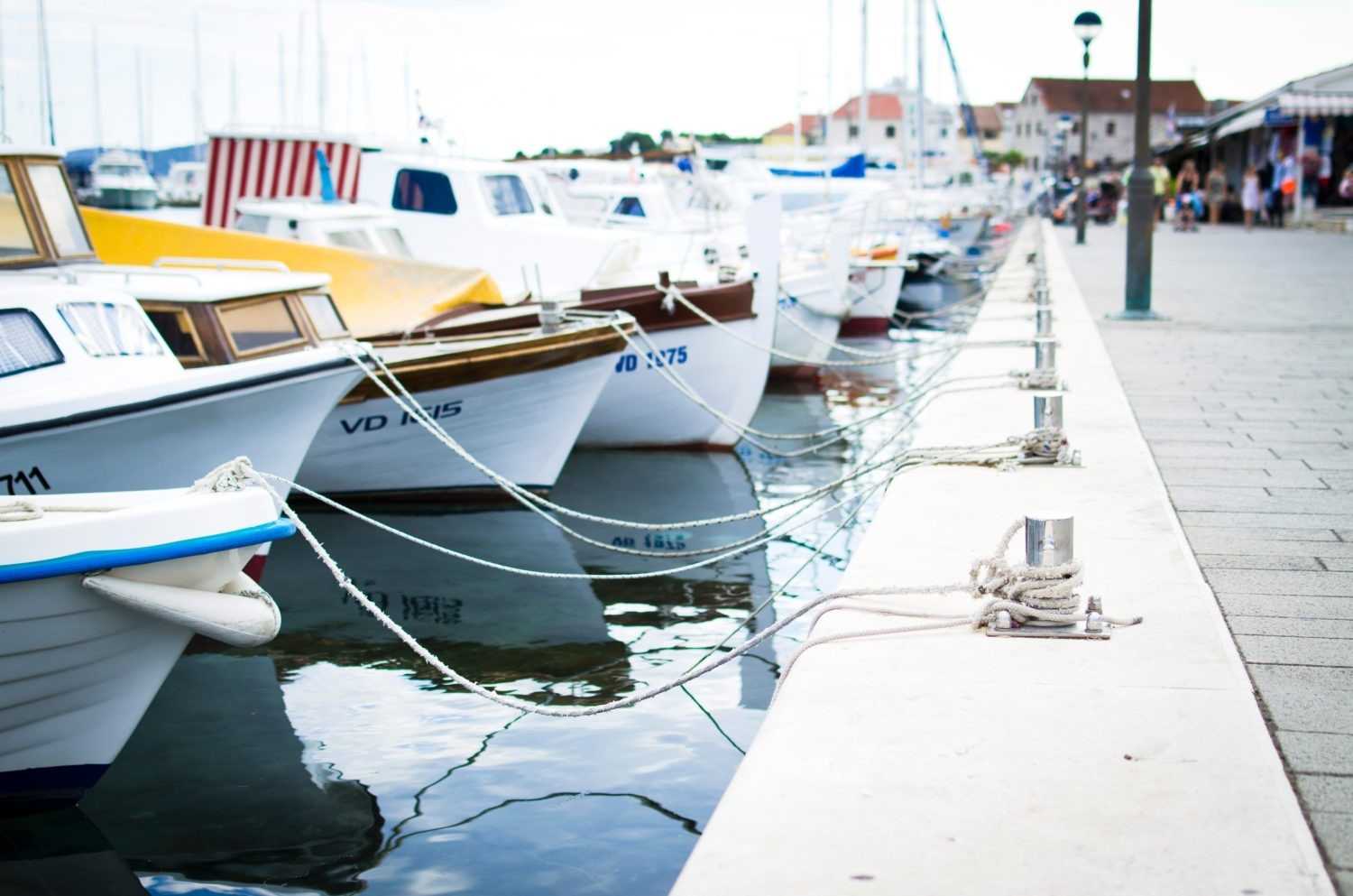 Boats docked along a waterfront marina beside a walkway in British Columbia, Canada